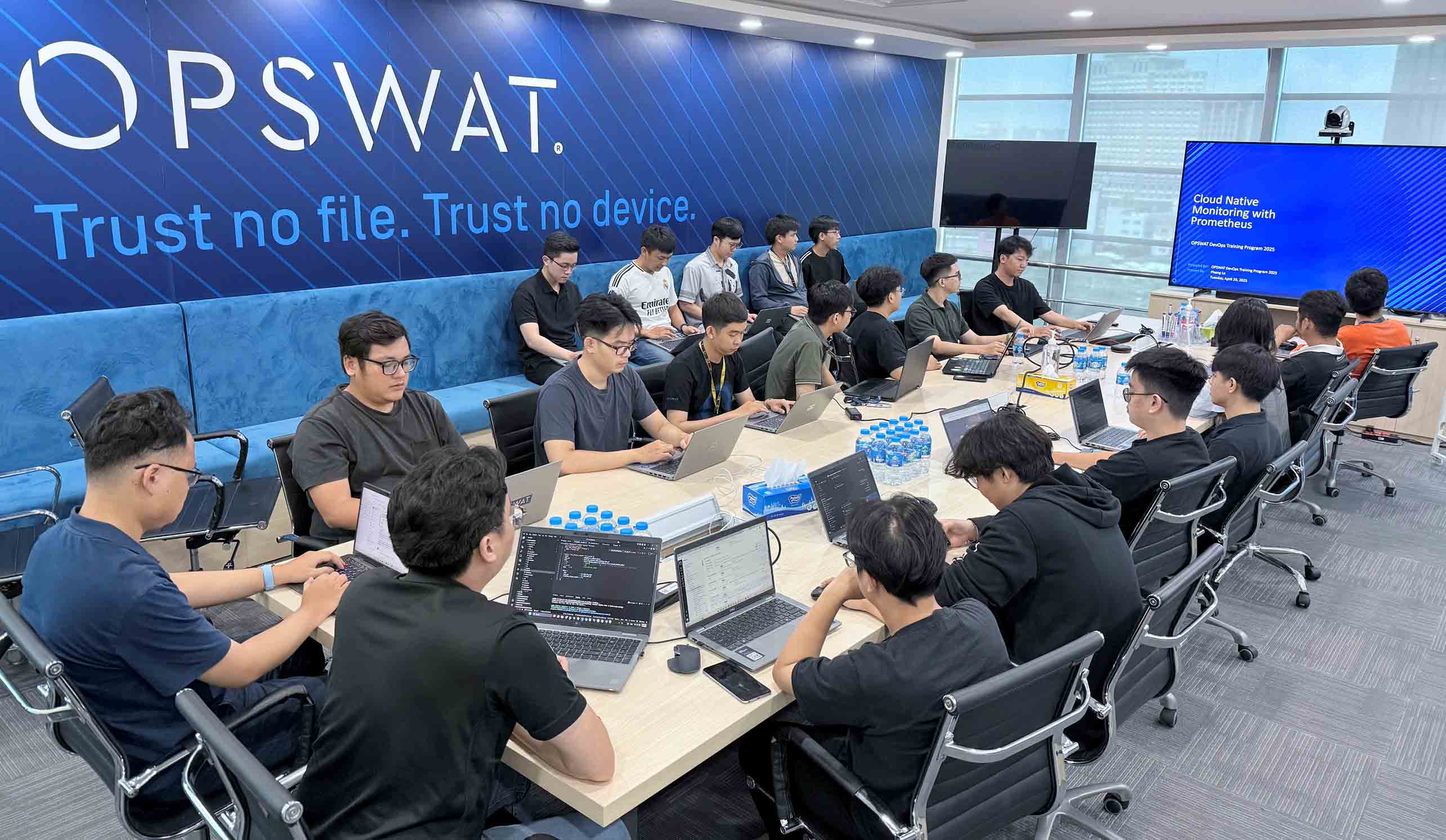 Thực tập sinh tại OPSWAT Đào tạo an ninh mạng DevOps và CloudOps 2025, cộng tác bằng máy tính xách tay trong phòng họp hiện đại