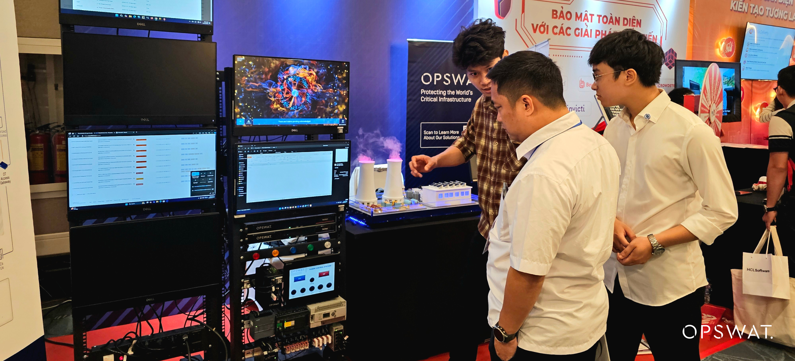 Katılımcılar bir etkinlik sırasında OPSWAT standında sergilenen siber güvenlik çözümlerini inceliyor