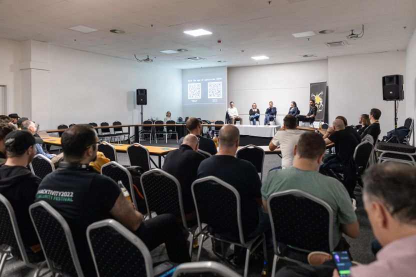 MetaDefender Sandbox Team presents groundbreaking research at a conference panel with audience and screen