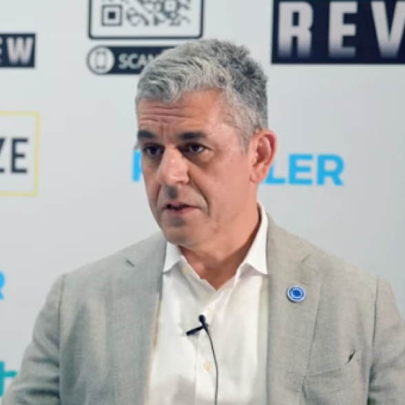 OPSWAT CEO'su Benny Czarny, hafif takım elbisesiyle etkinlikte konuşuyor