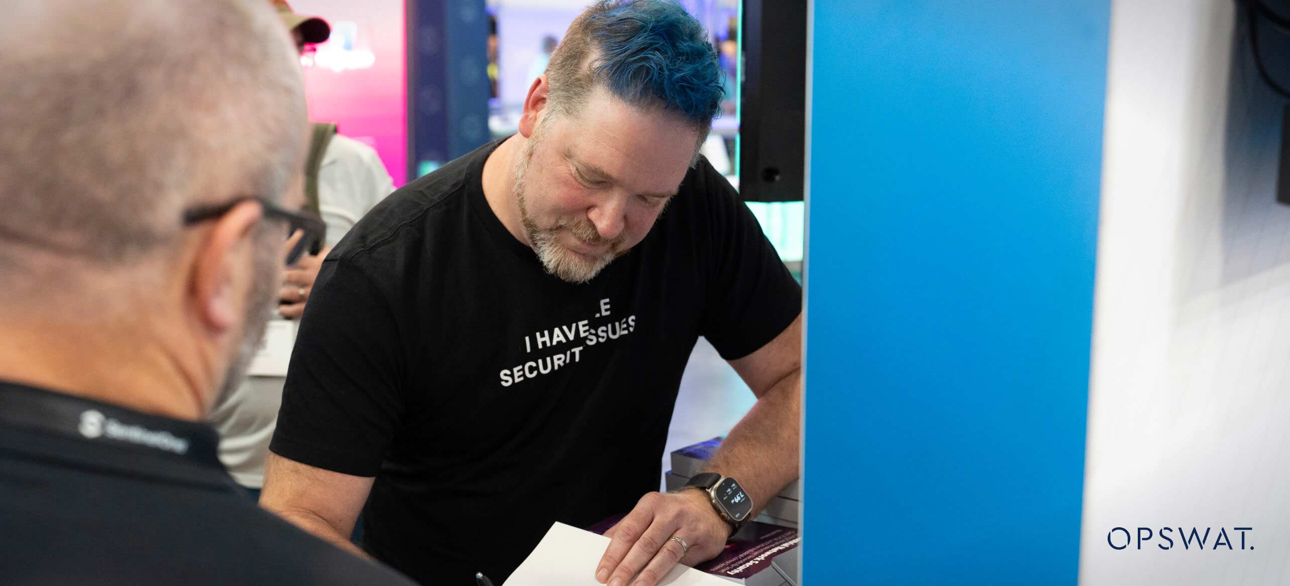 OPSWAT team member interacting with attendees at a conference booth