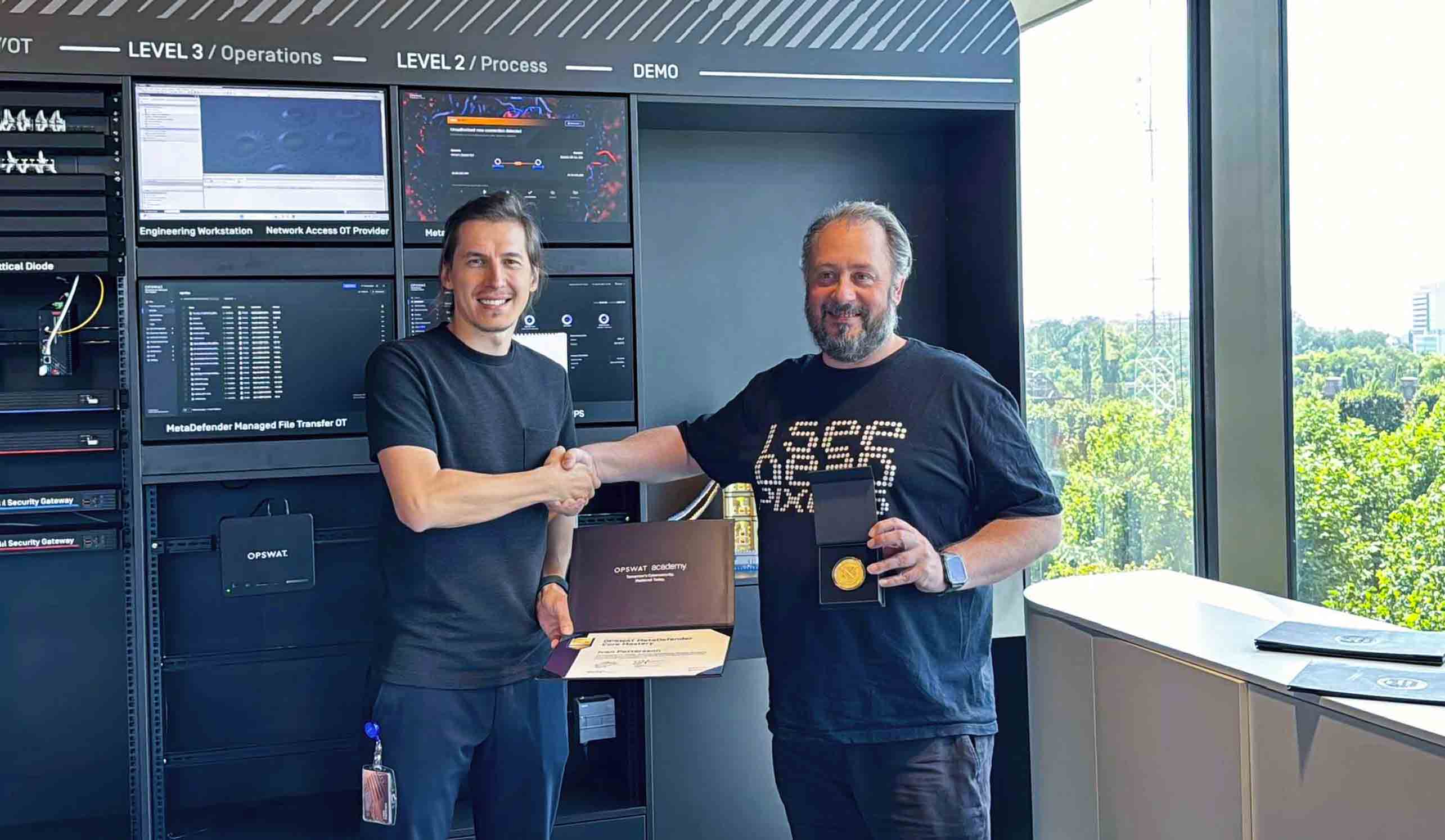 Two people at OPSWAT Academy bootcamp in Timisoara shaking hands, holding certificate and medal for cybersecurity achievement