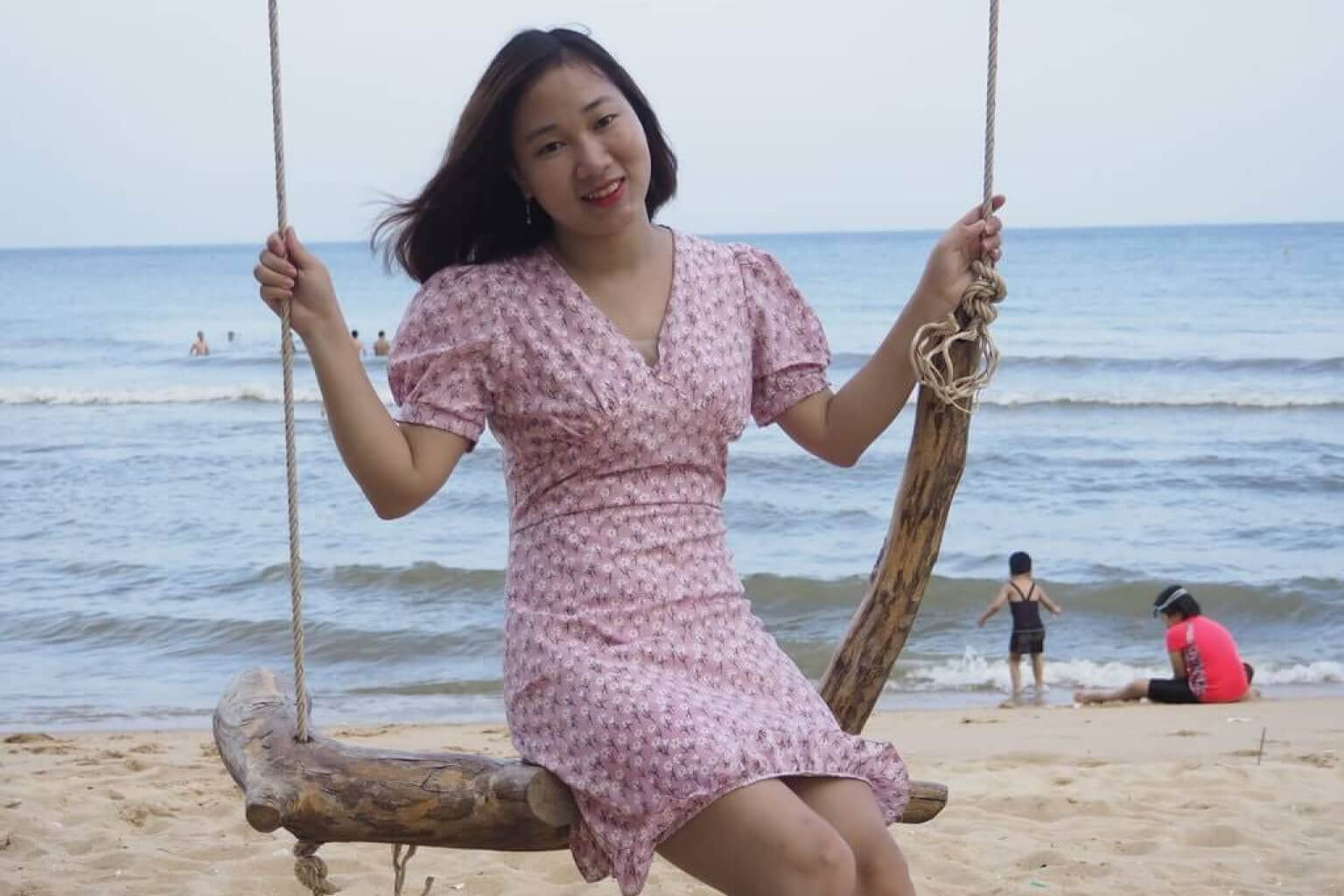 femme assise sur une balançoire à branches devant l'océan