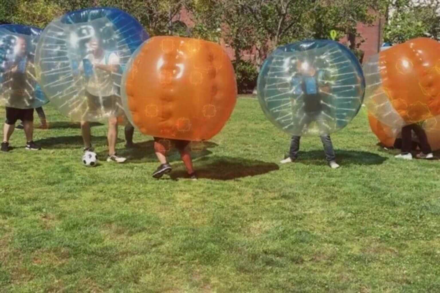 personnes jouant au football dans des ballons à bulles