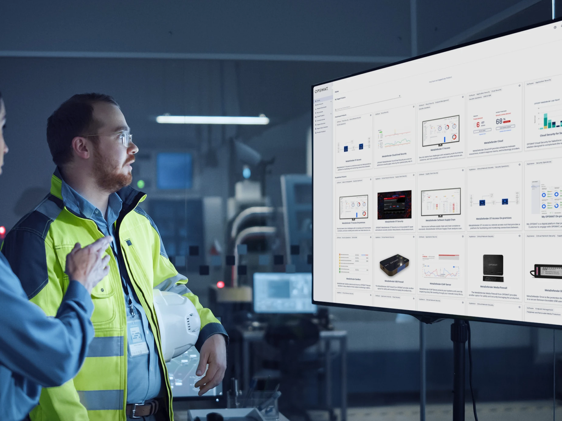 Man in a yellow reflective coat and holding a hardhart, looking at a screen with a benefits overview graphic for customers using My OPSWAT Portal