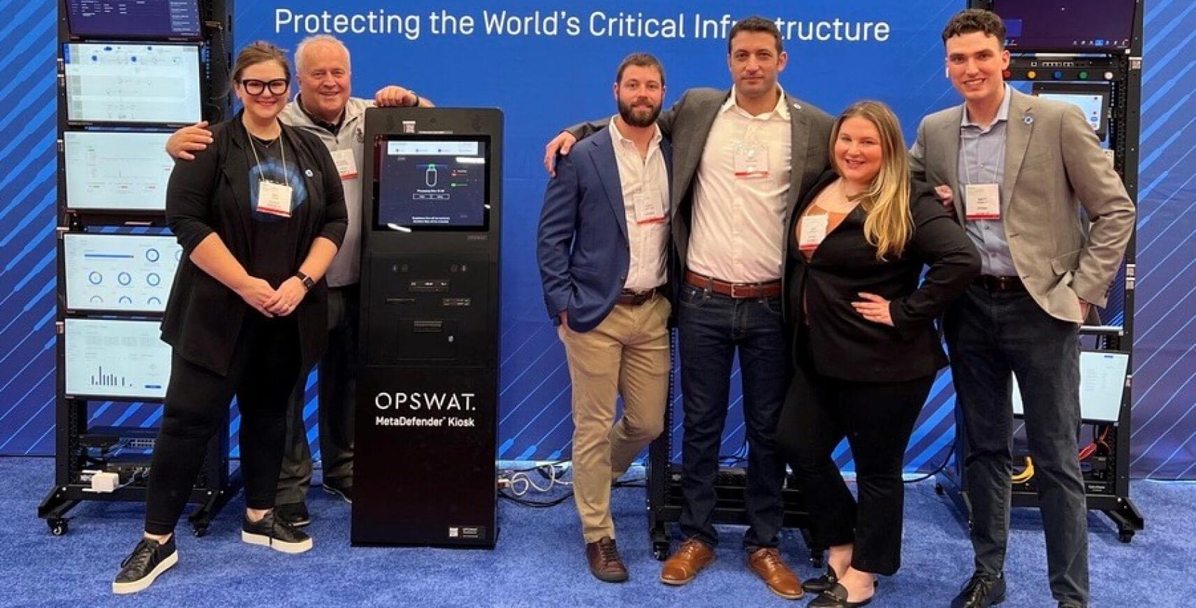 equipa de cinco pessoas num stand de exposição comercial com soluções OT OPSWAT , promovendo a proteção de infra-estruturas críticas