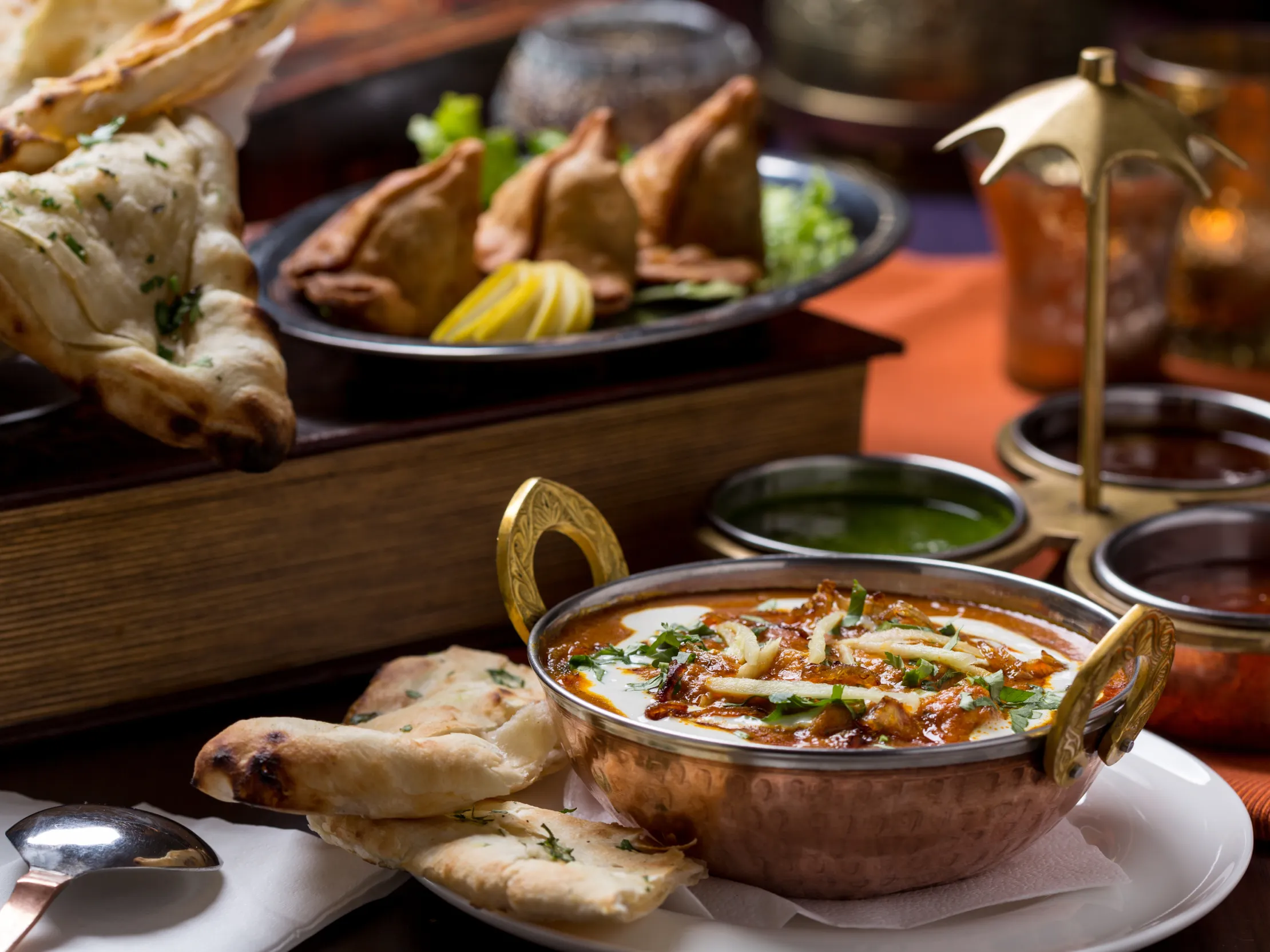 Indian cuisine with naan, curry, samosas, and chutneys