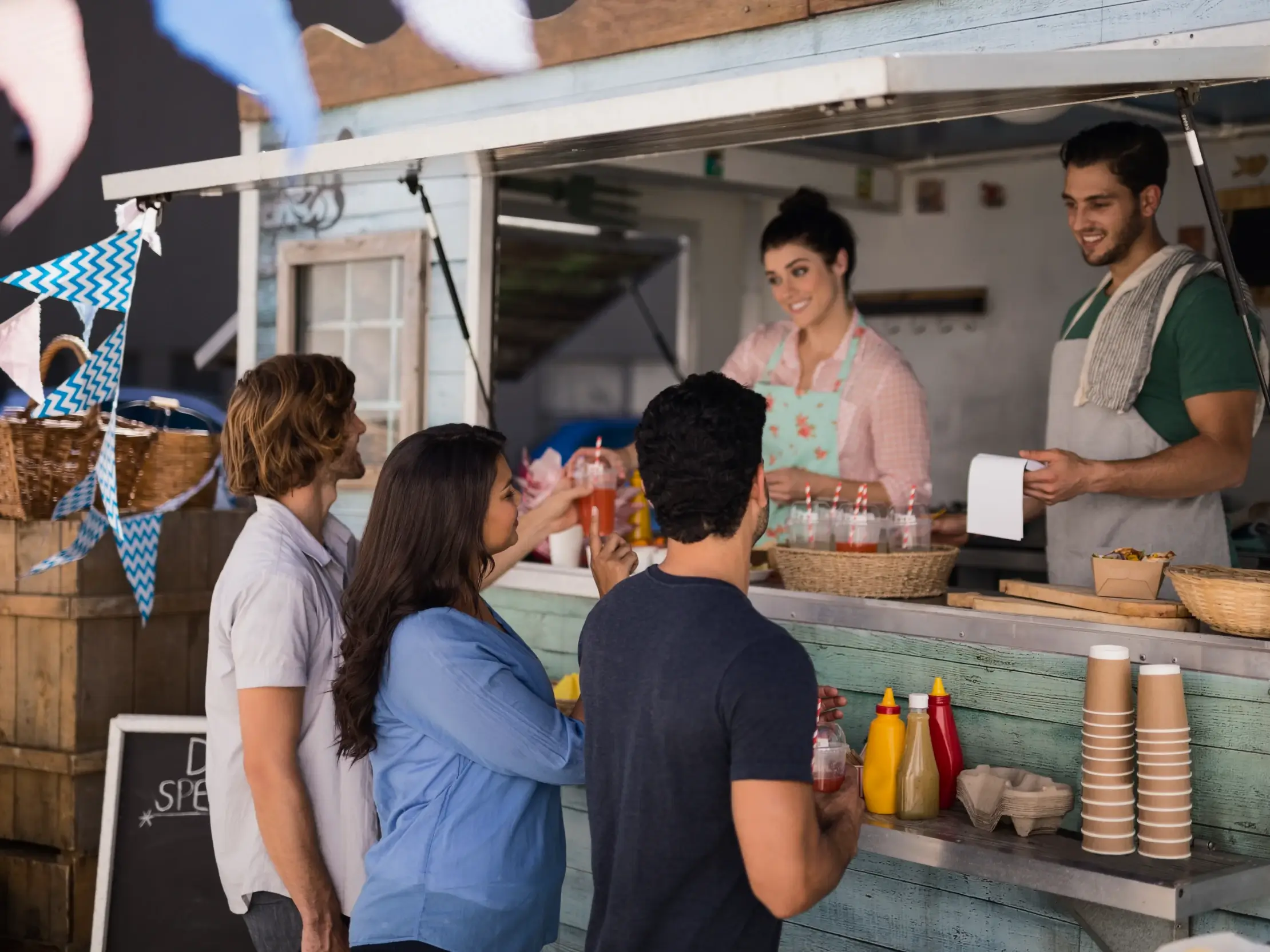 People gathered at a food kiosk, unrelated to OPSWAT Tampa Ybor City cybersecurity production facility event
