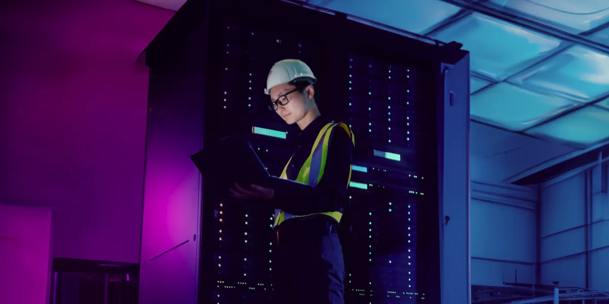 Engineer in data center reviewing server for securing classified data with cross domain solutions